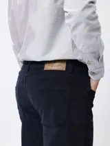 Pantalon de pana color tostado, de corte regular fit, con cinco bolsillos clásicos, cierre de botón y cremallera.