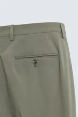 Pantalón de vestir regular fit confeccionado en tejido con lana, con bolsillos frontales y traseros de doble vivo con botón, cierre frontal con cremallera y botón.