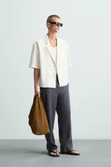 Camisa blanca de manga corta con cuello de solapa de muesca y cierre cruzado de doble botonadura.