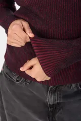 Sweater de punto acanalado negro con sutiles destellos cobrizos, de cuello redondo y manga larga.