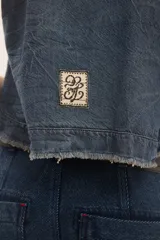 Top de jean blanco sin mangas, con escote redondo, espalda deportiva, costuras pespunteadas en el frente y ruedo desmechado.