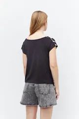 Blusa blanca con estampado de flores negras, escote en V y mangas cortas.