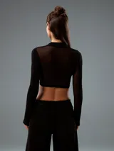 Top negro con cuello alto, mangas largas de tul y corte crop.