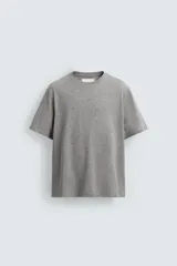 Camiseta de corte relajado confeccionada en algodón, con cuello redondo acabado en rib y manga corta.