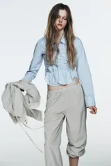 Pantalón bombacho de tiro medio con cintura elástica, confeccionado en tejido de nylon con estampado de cuadros pequeños en blanco y negro. El bajo es elástico con abertura y botón a presión.