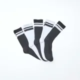 Lote de cinco pares de medias deportivas de caña media, dos pares de color blanco con dos rayas negras en la parte superior y tres pares de color negro con dos rayas blancas en la parte superior.