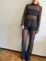 Pantalón de red negro con short interno y corte acampanado.