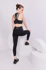 Top deportivo negro con espalda cruzada, elástico inferior y tiras regulables con logo Basset.