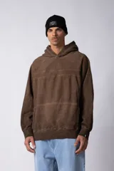 Buzo canguro de frisa gruesa con capucha, diseño oversize y acabado con efecto gastado. Presenta recortes horizontales en el frente y puños con elástico.