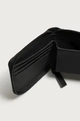 Tarjetero de diseño compacto en color negro con textura microtexturizada y cierre perimetral de cremallera. Cuenta con compartimentos internos para tarjetas.
