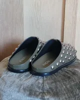 Zuecos negros de cuero vegano con tachas plateadas.