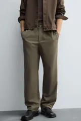 Pantalón regular fit color marrón oscuro, confeccionado en tejido con viscosa. Cuenta con cintura elástica, bolsillos delanteros y detalle de bolsillos traseros de vivo. El cierre frontal es con cremallera y botón.