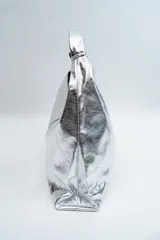 Bolso tipo hobo de diseño minimalista en color plateado metalizado, con acabado texturizado y asa integrada.