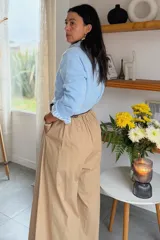 Pantalón de corte amplio y tiro alto, confeccionado en una mezcla de algodón y tencel. Presenta diseño de pinzas en la cintura, cierre frontal y caída fluida.