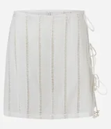 Minifalda de playa color crudo, con detalles de laise calado y ajuste lateral con lazos terminados en caracoles.