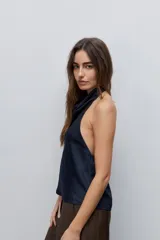 Top negro de cuello drapeado con espalda descubierta y calce fluido.