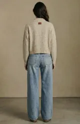 Cardigan de punto en tono beige melange con efecto jaspeado, de corte al cuerpo y manga larga. Presenta cierre frontal con botones oscuros y dos bolsillos delanteros aplicados.