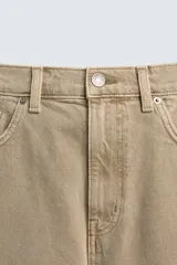 Bermuda de denim de algodón, color verde claro lavado, de corte recto y tiro medio. Presenta cinco bolsillos y cierre frontal con cremallera y botón.