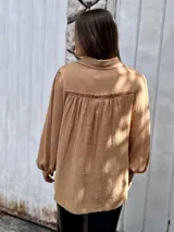 Camisa color beige de muselina con bordado en la parte delantera y mangas globo.