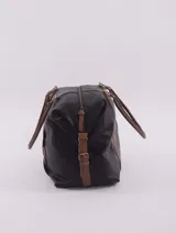Bolso de viaje tipo duffle, confeccionado en cuero natural color azul con textura, con detalles de correas y asas en cuero color suela. Cuenta con cierre superior, bolsillo interior con cierre y compartimento para celular.