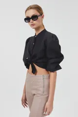 Pantalón de cuero color beige, de corte recto, tiro medio y tajos en el ruedo.