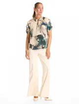 Blusa de gasa con estampado abstracto en tonos verdes, azules y beige. Presenta cuello mao fruncido con escote en V regulable mediante lazos, y mangas cortas con volados y puños elásticos.