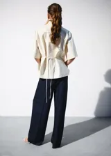 Pantalón de traje tiro medio, corte recto y largo, con diseño de raya diplomática, pinzas y bolsillos laterales.