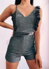 Mono corto blanco con escote en V, breteles finos y un volado en el hombro izquierdo.