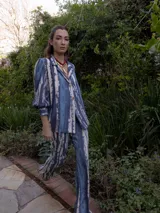 Blazer de edición limitada con estampado tie-dye en tonos azules y blancos, hombros sutilmente marcados y manga larga con puño ancho.