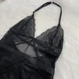 Body de encaje y microtul negro con diseño de escote halter, espalda descubierta y cierre con ganchos. Presenta paneles de encaje floral y secciones de tul transparente.