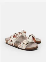 Sandalia de cuero con estampado animal print, con planta anatómica de corcho y dos tiras ajustables con hebillas metálicas doradas. Las tiras presentan textura de pelo suave al tacto.