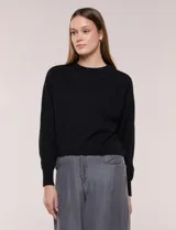 Buzo cropped negro de tejido texturizado, con cuello redondo y mangas largas raglán con puños ajustados.