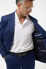 Ambo formal compuesto por saco de dos botones con solapas clásicas y bolsillos con solapa, y pantalón de vestir a juego, confeccionado en tela de alta calidad color azul marino.