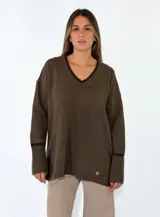 Sweater de punto color bordó con cuello en V, manga larga con puños acanalados y detalle de franja en contraste. Presenta un diseño holgado con aberturas laterales.