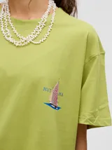 Remera verde agua con cuello redondo y manga corta, con un pequeño estampado de una estrella en el pecho. Corte holgado y cuadrado.