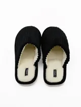 Pantuflas cerradas de pana negra con interior de corderito sintético color crema.