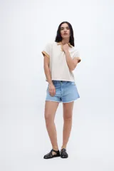 Remera con cuello tipo polo y escote en V, a rayas horizontales color beige y blanco, con cuello y mangas color beige liso.