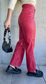 Pantalón de cuero sintético color rojo, de corte recto y tiro alto, con costuras blancas a contraste.