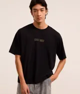 Remera boxy de algodón negro con cuello redondo, manga corta y estampa frontal con el texto "Guns N' Roses".