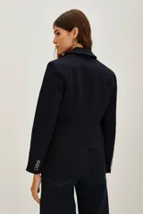 Saco sastrero de denim azul oscuro con costuras a contratono, combinación de forrería en cuerpo y mangas. Tiene botones a tono personalizados en cruce y mangas.