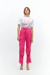 Pantalón de lino color fucsia, de corte relajado con cintura elástica y lazo ajustable. Presenta bolsillos ojal y detalle de presillas con botones en los tobillos que permiten ajustar el ruedo.