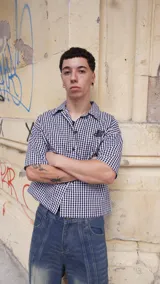 Camisa de corte boxy fit confeccionada en algodón con estampado de cuadros vichy en blanco y negro. Presenta un diseño gráfico artístico en color negro y blanco en la parte posterior.