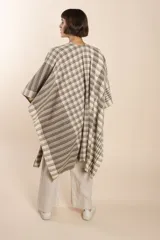 Ruana de lana fina color crudo con terminación envivada.