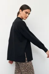 Polera color beige de manga larga con puños elastizados y aberturas laterales.