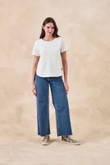 Remera de algodón color blanco con bordados florales y geométricos en color negro. Presenta cuello redondo, mangas cortas y un diseño con franjas horizontales bordadas.