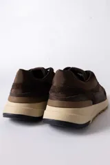 Championes urbanos de diseño técnico, combinando paneles de gamuza y tela técnica en tonos marrones. Presenta una entresuela de plataforma en color crema con suela dentada de goma.