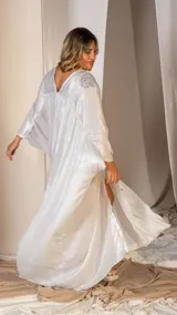 Levita larga de color plateado con diseño holgado tipo kaftan. Presenta cierre frontal con botones y detalles de bordado con pedrería en los hombros. Las mangas son amplias y el largo llega hasta los pies.