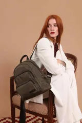 Mochila urbana de diseño funcional en color beige, confeccionada en tela impermeable. Cuenta con un compartimento principal amplio, un bolsillo secundario y un bolsillo frontal, todos con cierre. Incluye asa superior y correas ajustables para los hombros, con detalle de etiqueta de marca en el frente.