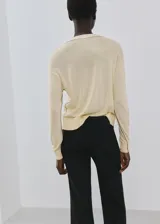 Jersey de punto fino color amarillo claro, con escote en V y manga larga.