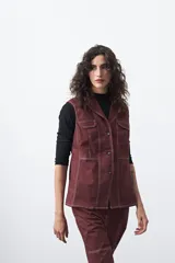 Chaleco de estilo utilitario color bordó con pespuntes blancos a contratono. Presenta solapas, cierre frontal con botones, bolsillos delanteros y un diseño estructurado.